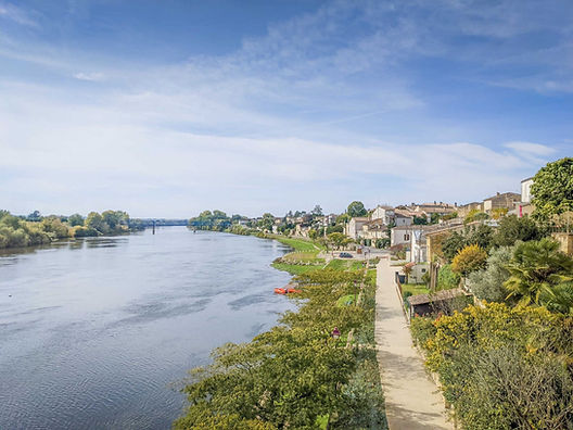Promenade au bord de la Dordogne à Castillon-la-Bataille, village viticole paisible près de Bordeaux, parfait pour une escapade sans voiture.