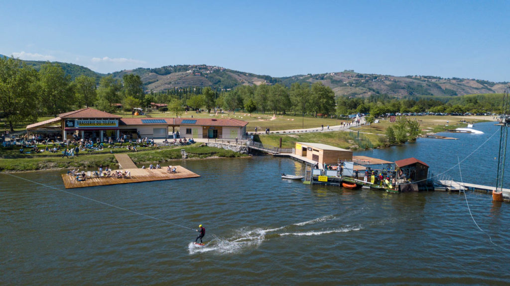 Vue aérienne du Wam Park à Les Roches-de-Condrieu, wakeboard et structures aquatiques sur le Rhône, accessible en 25 min de train depuis Lyon.
